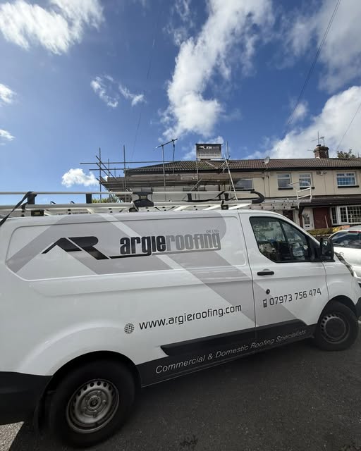 Argie Roofing van beside a scaffolded roofing project