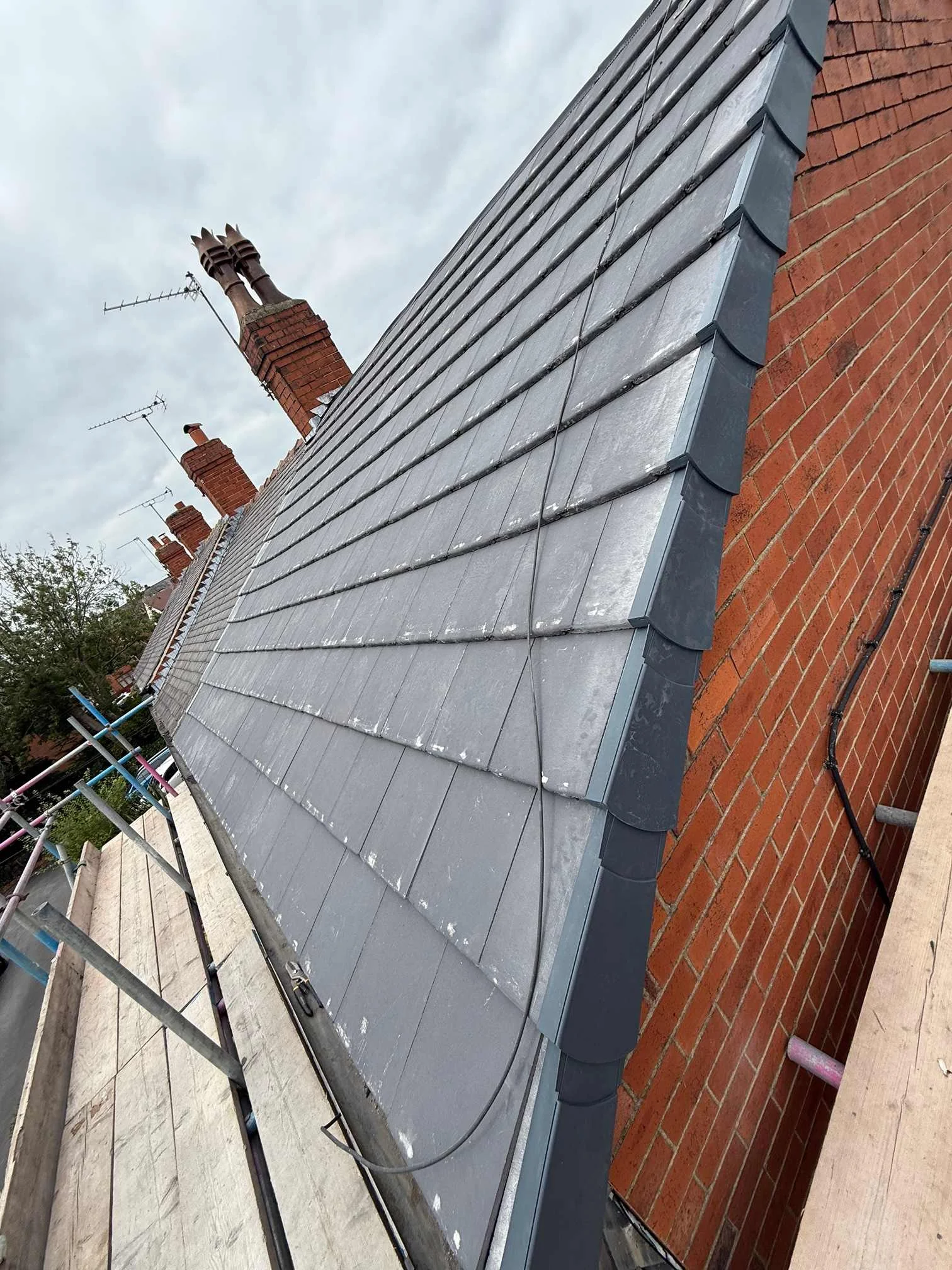 Slated roof with a finished verge beside a brick gable